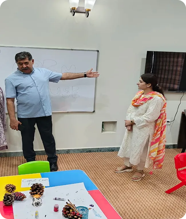 Teacher and colleague discussing at a whiteboard in a classroom